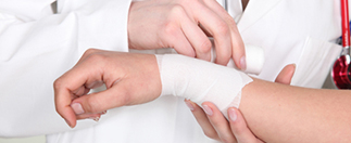 Doctor putting bandage on wrist